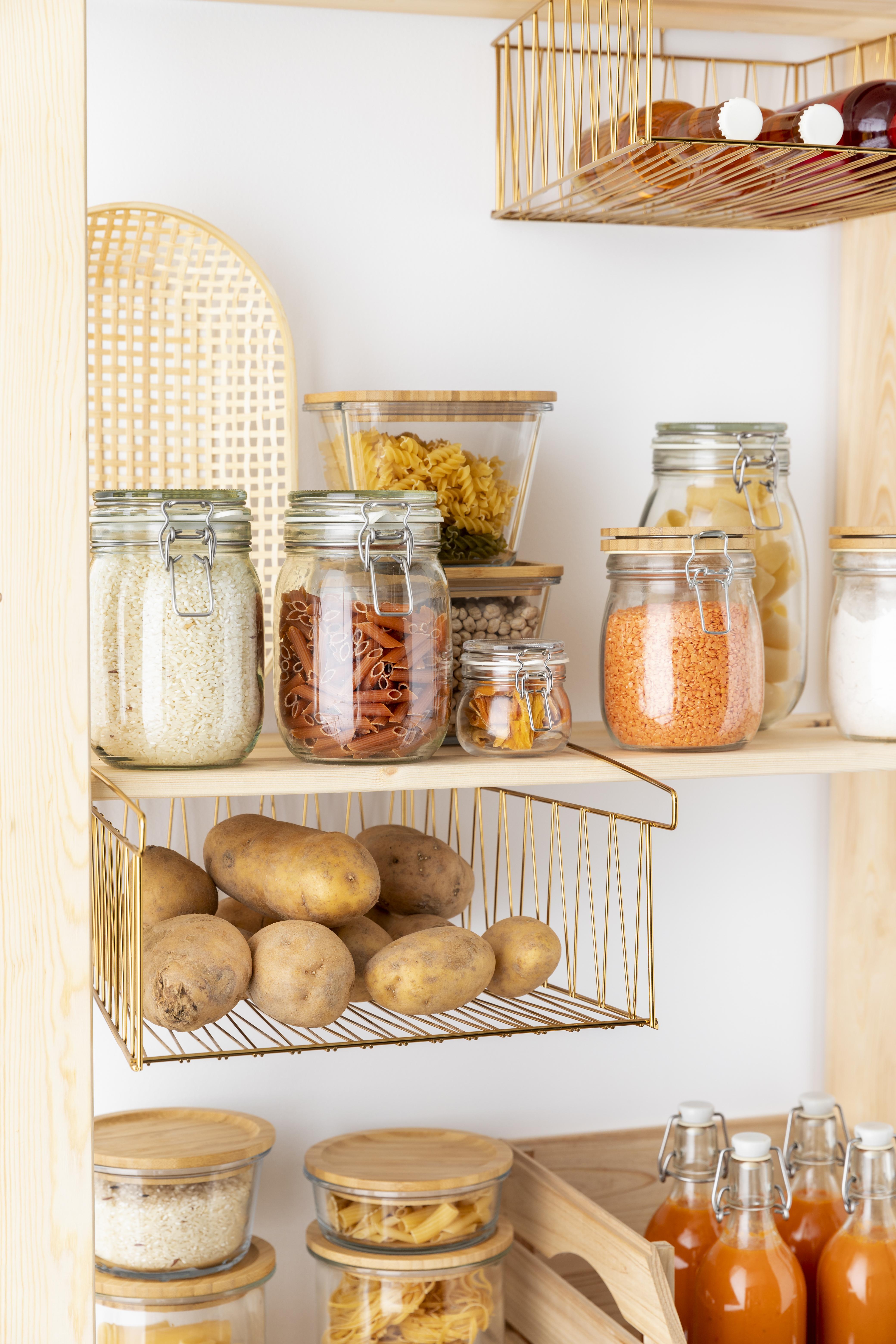 Dry foods like rice, pasta and lentils stored in sealed glass jars on organised kitchen pantry shelves